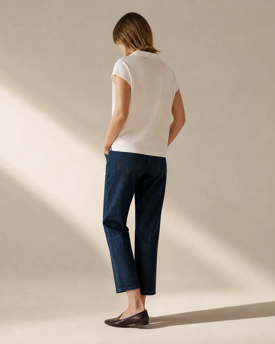 Kırık beyaz bol polo tişört ve koyu mavi crop denim pantolonla özgün editoryal kombin