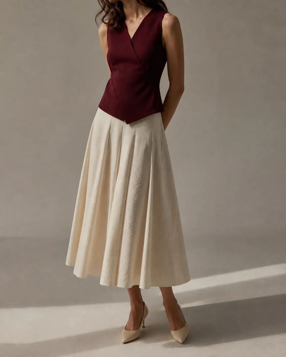 Bordo kolsuz bluz ve ekru floral dokulu pileli midi etekten oluşan kadın kombini